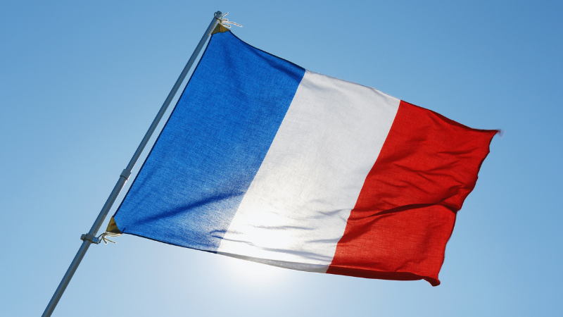 Drapeau français flottant, symbole de ta nouvelle vie professionnelle en France